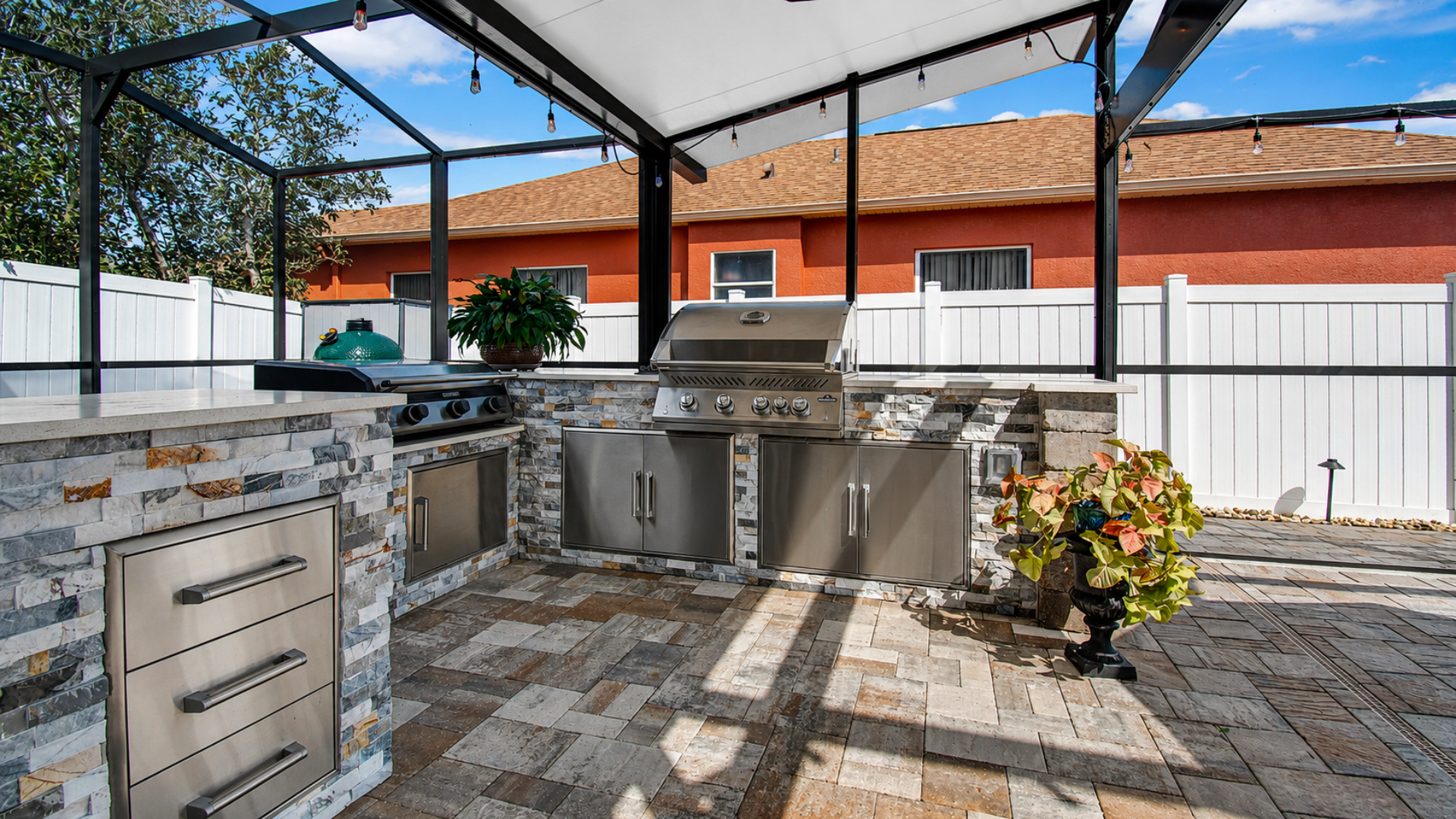 Outdoor Custom Grill Area with built-in appliances under a screened enclosure